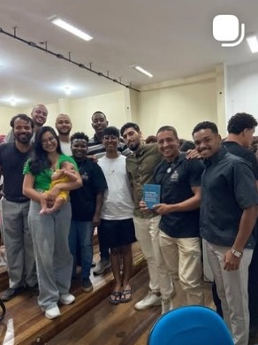 Grupo de jovens posando em um auditório